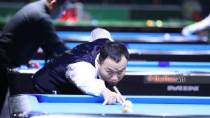 a man lying on the pool table with a woman looking at the ball